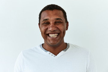 African American man portrait against white background. Laughter and joy emotions