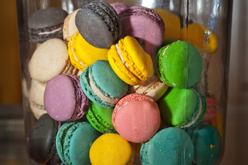 Multicolored sweets in the shop window. Many cakes on a glass shelf in a jar.
