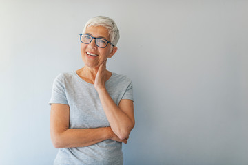 Beautiful business woman with short hairstyle isolated grey background. Portrait of happy Mature business woman middle aged woman smiling isolated on grey background