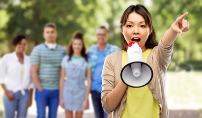 communication and human rights concept - asian young woman speaking to megaphone over group of people in summer park background