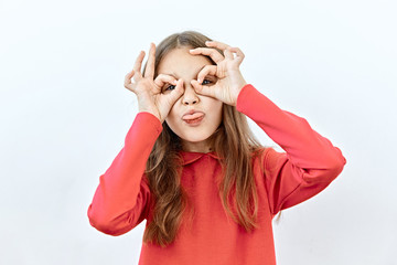 Making face,funny  foolishes portrait of Beautiful child girl do binoculars with tongue out ,against white background.