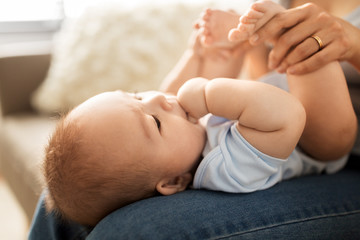 babyhood, family and motherhood concept - close up of little asian baby boy and mother