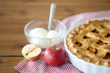 food, culinary and baking concept - apple pie with ice cream on wooden table