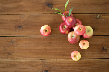 fruits, food and harvest concept - ripe red apples on wooden table