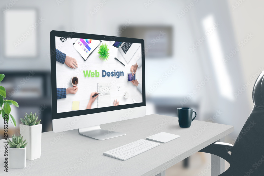 Wall mural web design text on computer display. concept of web design studio. work desk, office interior.