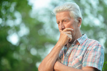 Portrait of thinking senior man in park