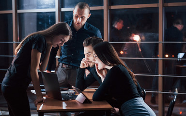 It is astonishing. Team of young business people works on their project at night time in the office