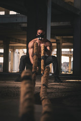 Obraz na płótnie Canvas Athletic man training with battle ropes