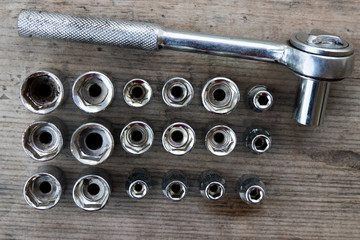 Ratchet Wrench  with attachments on a wooden board