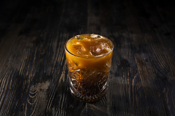 Party caffeinate cocktail with coffee and ice cubes alcoholic or non-alcoholic on a dark table. Low key light. Menu concept