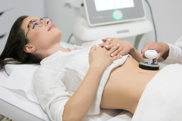 Slim woman getting anticellulite and anti fat therapy in beauty salon