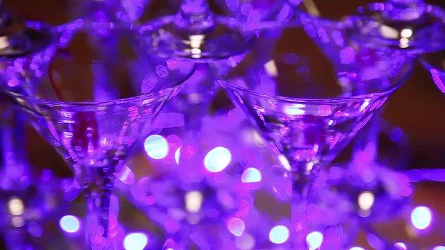 Pyramid of champagne glasses flashing colored lights. bartender Shaw