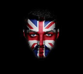 Flag of Great Britain painted on a face of a man on black background.