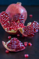 ripe sliced pomegranate on a dark background - 276530708