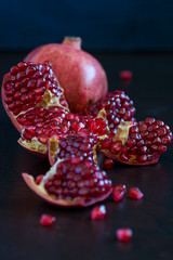 ripe sliced pomegranate on a dark background - 276530766