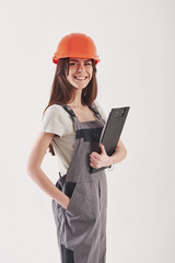 Long haired girl. Brunette woman in yellow uniform stands against white background in the studio with notepad in hand