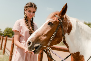 country girl feeding a horse on a ranch