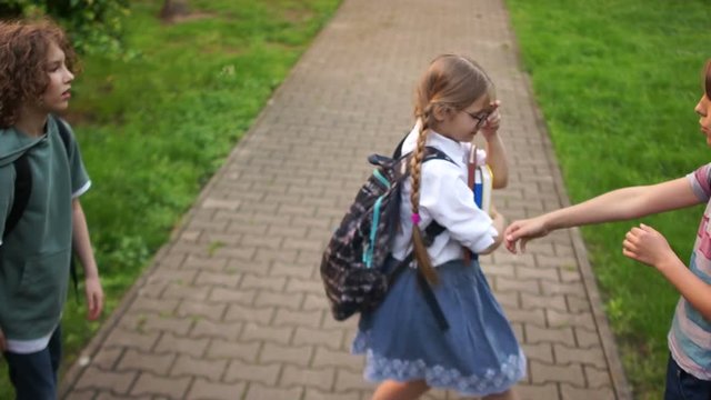 Group of teenagers are pushing and insulting a schoolgirl. Adolescent violence problem. Bullying among adolescents and schoolchildren. Physical violence