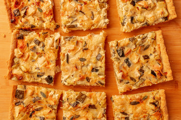 A closeup photo of a homemade zucchini and goat cheese pie with sage, shot from the top on a wooden cutting board
