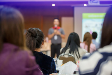 selective focus to business woman with blurry man speaker for meeting or seminar event in the...