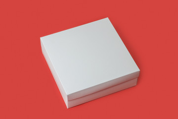 Белая коробка на красном фоне для любого продукта.