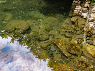 Stones and reflected blue sky in the water of a mountain stream.