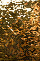 Sequins background. Background with shiny sequins on fabric. Abstract texture scales with gold sequins