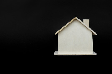 Wooden house model against black background