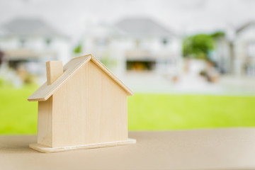 Obraz na płótnie Canvas Miniature house model on table in front of suburban houses