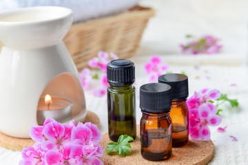 essential oils with rose geranium flower at spa salon - obrazy, fototapety, plakaty