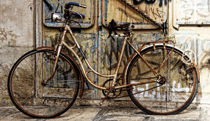 Old rusty bike at the door covered with graffiti