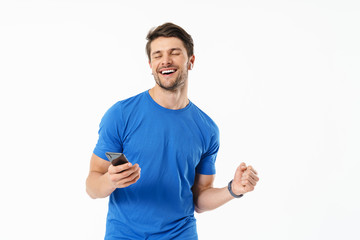 Photo closeup of happy man in casual t-shirt smiling and holding smartphone while wearing wireless earpods