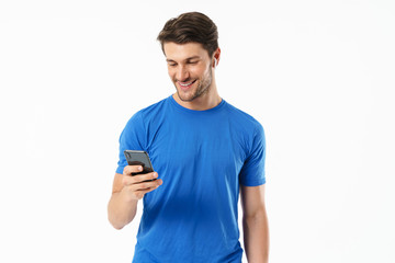 Photo closeup of masculine man in casual t-shirt smiling and holding smartphone while wearing wireless earpods