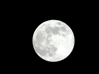 Obraz premium An amazing photography of the full moon over the city of Genova by night with a great clear and blue sky in the background and some stars.