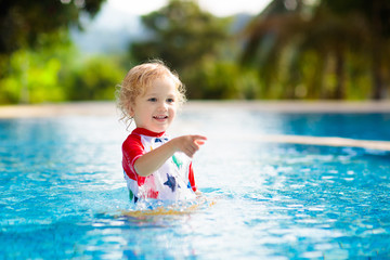 Fototapeta na wymiar Child in swimming pool. Summer vacation with kids.