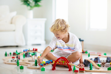 Kids play wooden railway. Child with toy train.