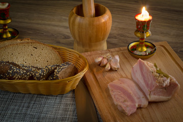 still life with burning candle bacon and sliced bread in a basket