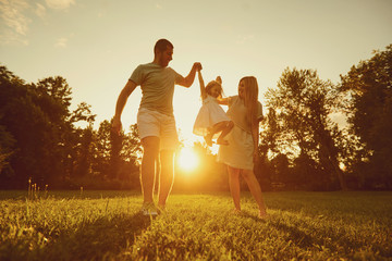 Family playing with a child at sunset on the nature