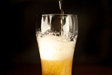 pour beer in a beer glass, tasty fresh beer in a beer grocery glass