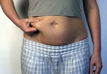 Naklejka premium young woman and excess belly fat