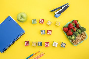 Lunchbox and stationery with writing on table