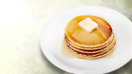 Stack of Small pancakes in syrup on background