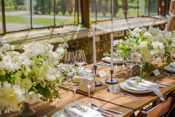 Wedding decor, floristics, white flower arrangements with candles and a server table