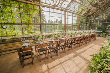 Wedding banquet hall decorated in modern style, compositions of white flowers and lots of greenery