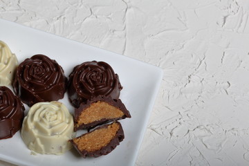 Homemade sweets. Chocolate coated sweets with almond filling. Cake pops decorated with a bow of braid. 