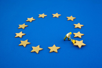 Brexit concept. The figure pushes one star out of the Europen Union Flag