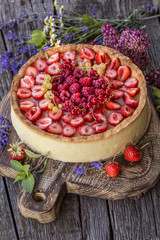 tart with fresh strawberries, raspberries and currants in a rustic style