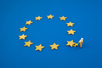 Brexit concept. The figure pushes one star out of the Europen Union Flag