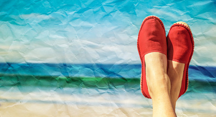 Beine mit roten Stoffschuhen vor Strand und Meer