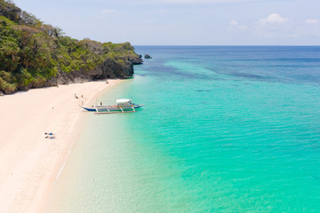 Fototapeta na wymiar Puka Shell Beach. Wide tropical beach with white sand. Beautiful white beach and azure water on Boracay island, Philippines, top view. Tourists relax on the beach.